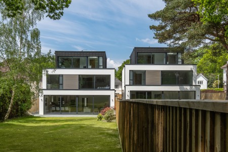 Rear grden view of zinc clad, white rendered, glass frontage contemporary houses designed